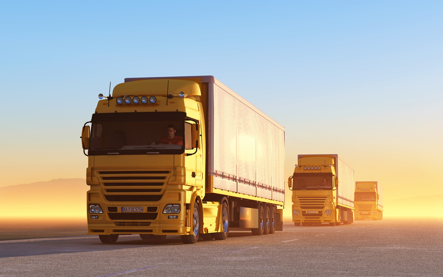 a convoy of semi trucks on a dusty road